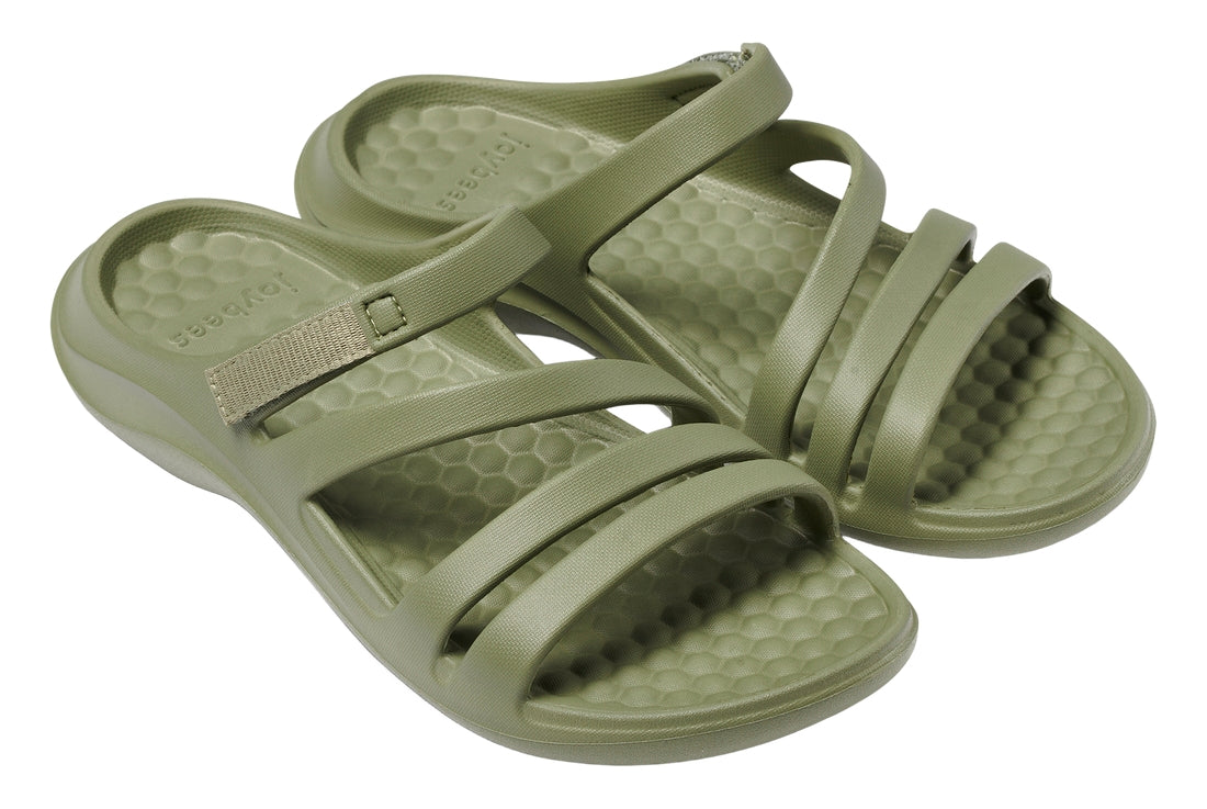 Pair of green sandals with textured sole on a white background