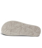 An outsole of a white REEF sandal with tropical pattern.