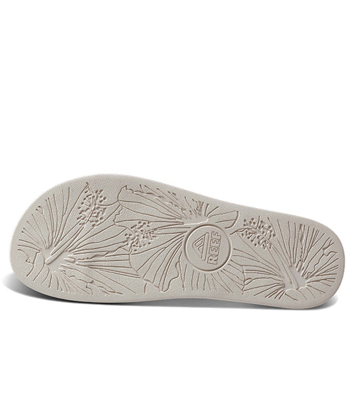An outsole of a white REEF sandal with tropical pattern.
